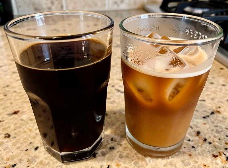 Side-by-side glasses of cold brew concentrate and freshly pulled iced espresso on a home coffee counter