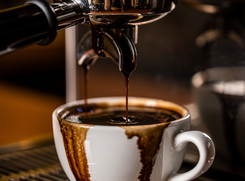 A slow, dark, over-extracted espresso dripping thickly from a portafilter, indicating bitterness