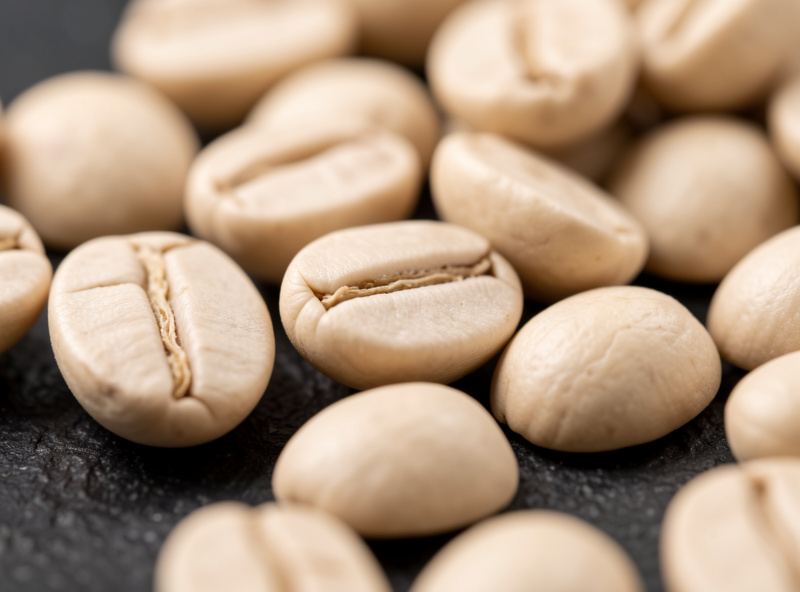 Close-up of light roast espresso beans showing pale tan color and dense surface